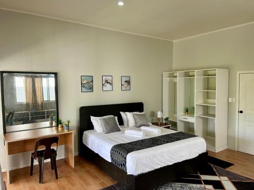 a bedroom with a bed and a desk and a bed and a table at Feiloakimisi Retreat King Ensuite with Private Veranda Free Parking in Nuku‘alofa