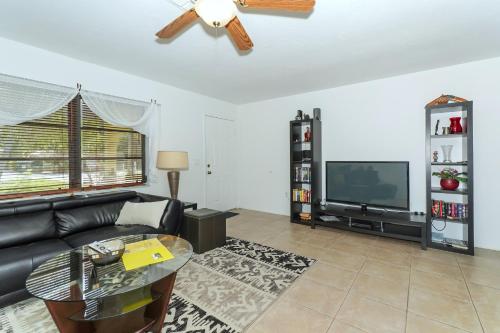 ein Wohnzimmer mit Sofa und Fernseher in der Unterkunft Tropical Fruit Garden in Sarasota