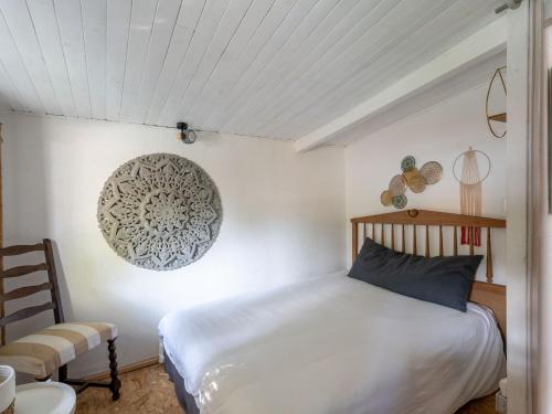 ein Schlafzimmer mit einem Bett und einem Stuhl in der Unterkunft Maison à Biscarrosse: 8 pers, piscine, clim, proche lac et pistes cyclables, ménage inclus - FR-1-319-538 in Biscarrosse