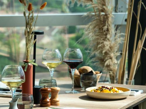a table with glasses of wine and a plate of food at Mercure Paris Orly Rungis Aéroport in Rungis