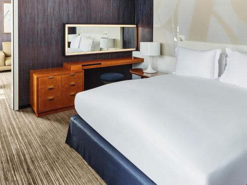 a hotel room with a bed and a mirror at Sofitel Luxembourg Europe in Luxembourg
