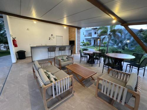 a patio with couches and tables and a bar at Maraville Vibes Macapa - Conforto pertinho do mar in Luis Correia