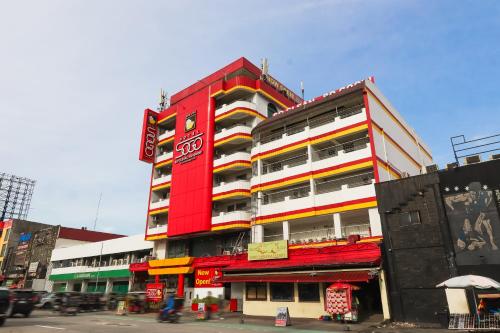 a tall red building with colorful balconies on a city street at Hotel Sogo Baclaran in Manila