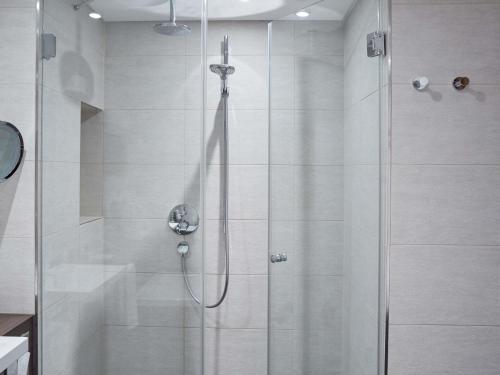 a shower in a bathroom with a glass door at Hotel Mondial am Dom Cologne MGallery in Cologne