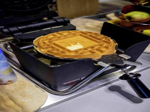 a waffle sitting on top of a waffle iron at Mercure Hotel Den Haag Central in The Hague