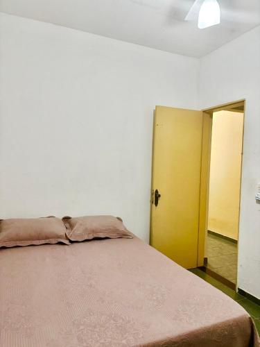 a bedroom with a bed and a yellow door at Casa de tartaruga em Guarapari in Guarapari