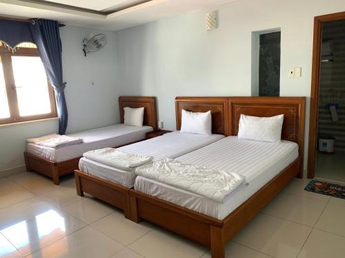 a bedroom with two beds and a window at Khách Sạn Quốc Hồng in Soc Trang