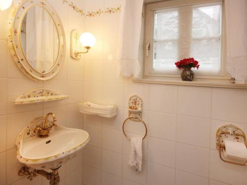 a white bathroom with a sink and a mirror at Holiday home half-timbered house Bodenwerder in Kemnade