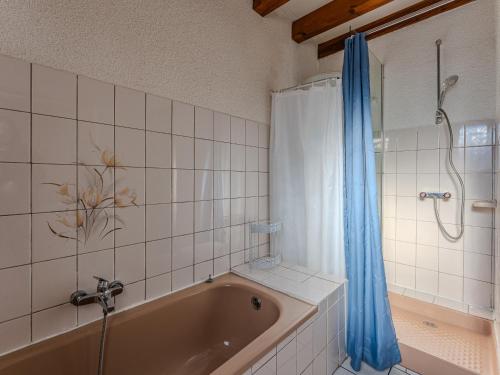 a bathroom with a tub and a shower with a blue curtain at Maison chaleureuse avec terrasse et jardin, proche plage et centre-ville - 6 pers, Biscarrosse - FR-1-521-34 in Biscarrosse-Plage