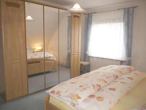 a bedroom with a mirror and a bed at Holiday apartment in Harz with 1 bedroom in Harlingerode