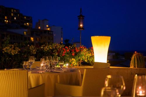 a table with wine glasses and a lamp at night at Grand Fiesta Americana Los Cabos All Inclusive Golf & Spa in Cabo San Lucas