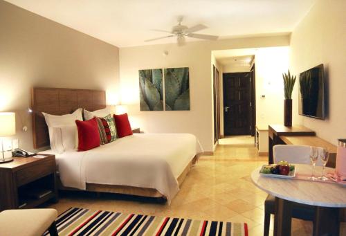 a hotel room with a bed and a dining room at Grand Fiesta Americana Los Cabos All Inclusive Golf & Spa in Cabo San Lucas
