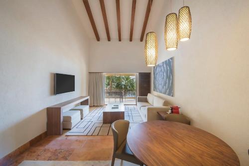 a living room with a table and a couch at Grand Fiesta Americana Los Cabos All Inclusive Golf & Spa in Cabo San Lucas