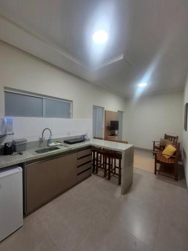 a large kitchen with a sink and a table at Flats de 2 quartos in Regente Feijó