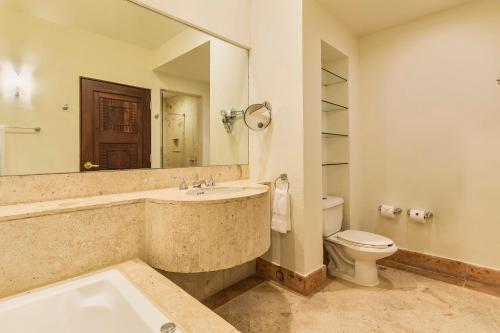 a bathroom with a sink and a toilet and a mirror at Grand Fiesta Americana Los Cabos All Inclusive Golf & Spa in Cabo San Lucas