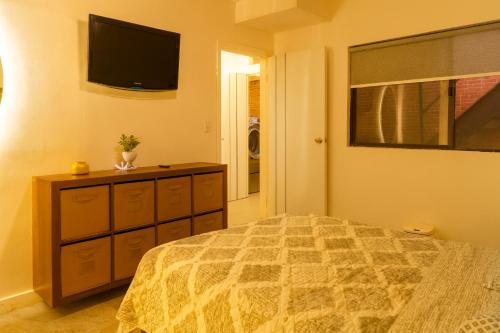 a bedroom with a bed and a tv on the wall at Departamento Confort Colinas in Chihuahua