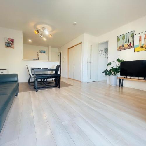 a living room with a table and a couch at Naha Airport, beaches, shopping centers are nearby #NewVilla in Itoman