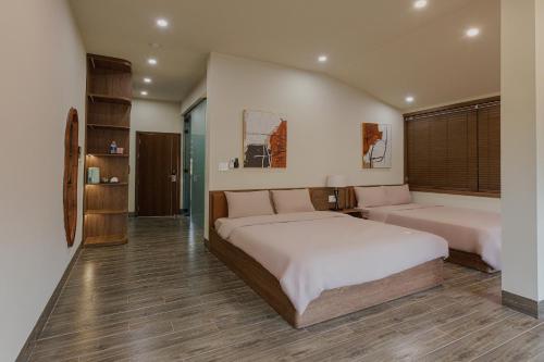 a bedroom with a large bed and a large window at Valley De Mango Hue in Thôn Châu Chữ