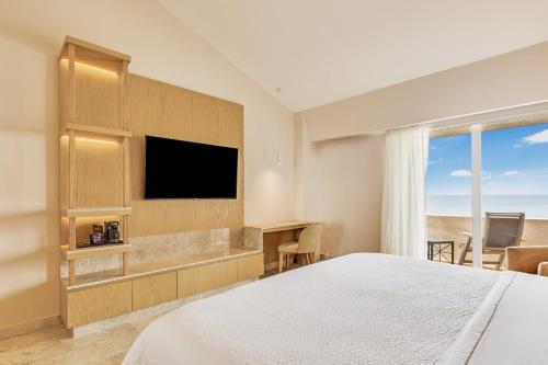 a hotel room with a bed and a flat screen tv at Fiesta Inn Veracruz Boca Del Rio in Veracruz