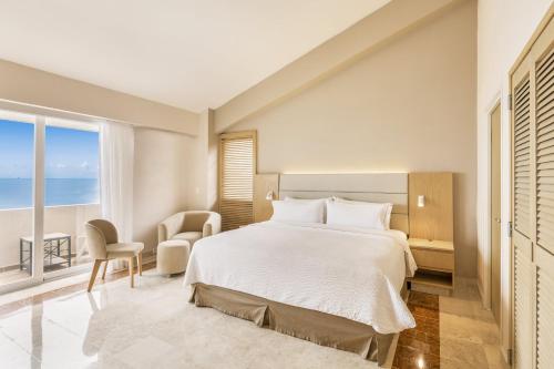 a bedroom with a large bed and a large window at Fiesta Inn Veracruz Boca Del Rio in Veracruz