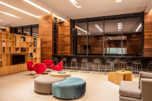 a lobby with chairs and tables and a bar at Fiesta Inn Tuxtla Fashion Mall in Tuxtla Gutiérrez