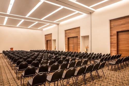 an empty room with rows of chairs in a hall at Fiesta Inn Tuxtla Fashion Mall in Tuxtla Gutiérrez
