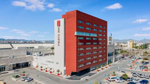 a red and white building with a parking lot at Fiesta Inn Torreon Galerias in Torreón