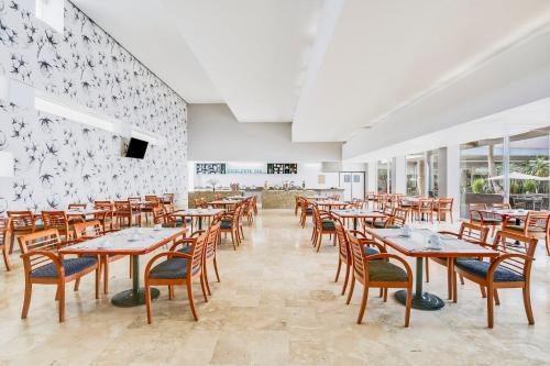 a dining room with wooden tables and chairs at Fiesta Inn Torreon Galerias in Torreón