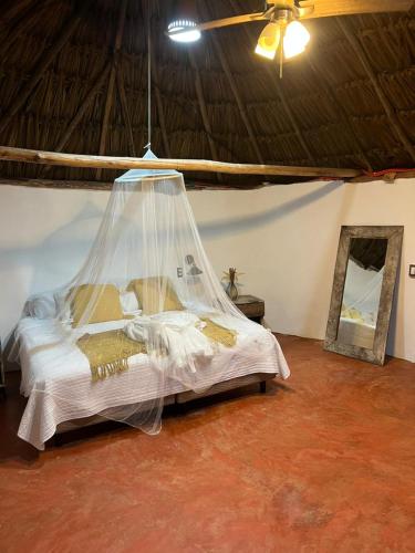 a bedroom with a bed with a mosquito net at Casa Pakluum in Felipe Carrillo Puerto