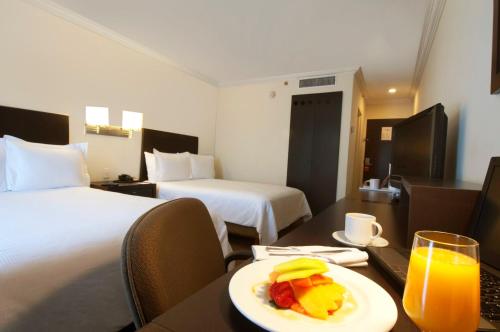 a hotel room with a plate of fruit on a table at Fiesta Inn Toluca Centro in Toluca