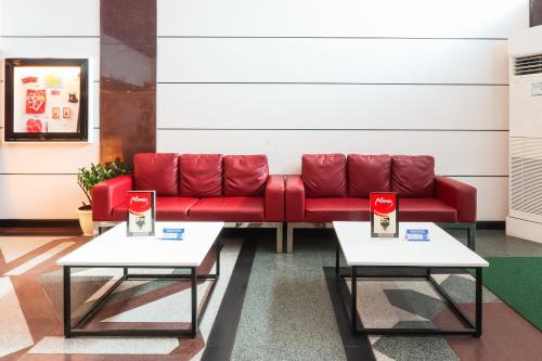 a red couch in a room with two tables at Hotel Sogo Baclaran in Manila