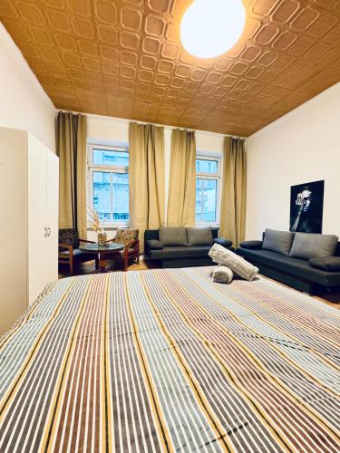 a bedroom with a large bed and a living room at Sweet Studio for 3P, 10 Min to FAC Platz in Vienna