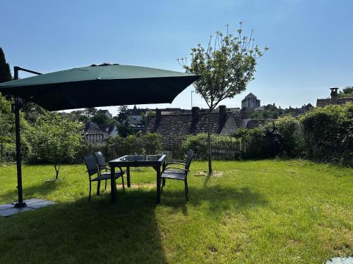 a table and chairs under an umbrella in a yard at Maison Rénovée avec Jardin et WIFI à La Roche-Posay - FR-1-541-173 in La Roche-Posay