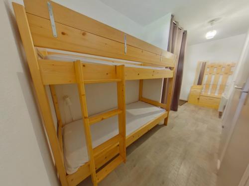 ein hölzernes Etagenbett in einem Zimmer in der Unterkunft Appartement cosy aux Rousses avec terrasse et proximité activités - FR-1-834-8 in Les Rousses