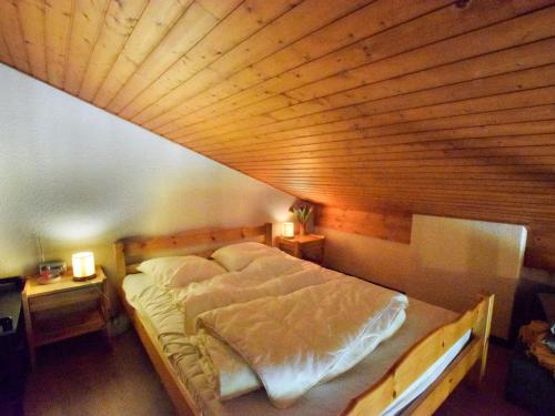 un lit dans une chambre avec un plafond en bois dans l'établissement Appartement duplex à Bernex - 4 personnes, garage, près des pistes - FR-1-498-88, à Bernex