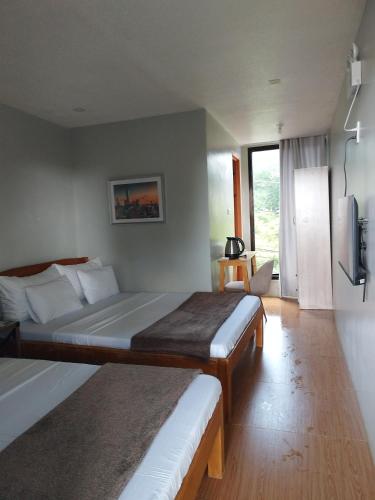 a hotel room with two beds and a television at Mamay's Homestay in Tagbilaran City