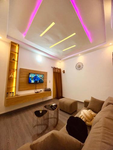 a living room with a couch and a tv at Sucram Appartement in Abomey-Calavi