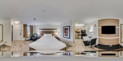a hotel room with a bed and a tv at MainStay Suites Knoxville - Cedar Bluff in Knoxville