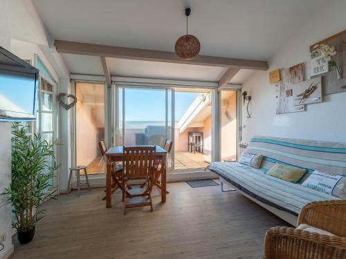 un soggiorno con un tavolo e un divano di Appartement 6 personnes à Mimizan avec parking, balcon et local à vélos - FR-1-50-126 a Mimizan