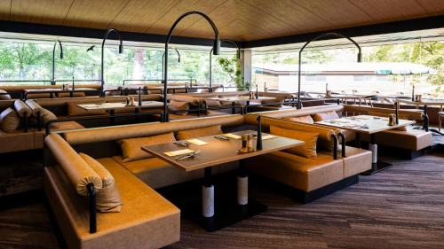 a restaurant with many tables and chairs and windows at Karuizawa Prince Hotel East in Karuizawa