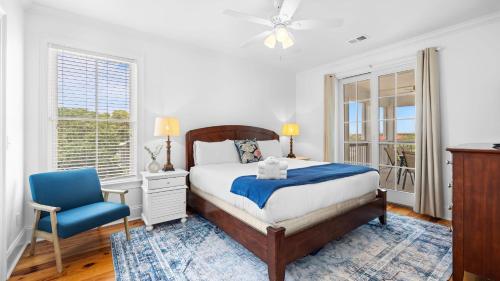 a bedroom with a bed and a blue chair at 1 Block to Beach Newly Renovated 6BDR w Rooftop Views Sand Dune by AvantStay in Mount Pleasant