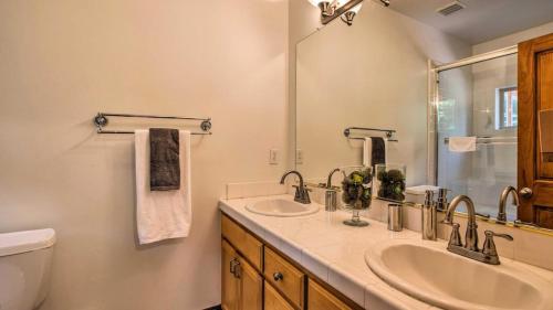 a bathroom with two sinks and a toilet and a mirror at Moosetrack by AvantStay Cozy Cabin In The Heart of Tahoe Donner in Truckee
