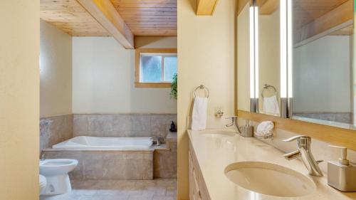 a bathroom with a tub and a sink and a toilet at Ember by AvantStay Majestic Entertainers Home w Pine Tree Views Close to Meeks Bay in Tahoma Meadows