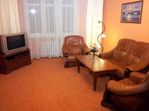 ein Wohnzimmer mit 2 Stühlen und einem TV in der Unterkunft Apartament Classic Gdynia in Gdynia