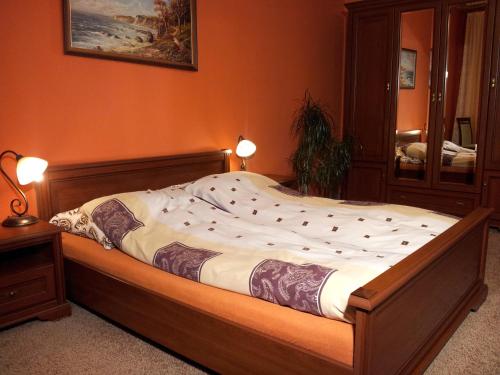 ein großes Bett in einem Zimmer mit orangefarbenen Wänden in der Unterkunft Apartament Classic Gdynia in Gdynia