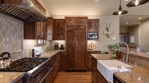 a kitchen with wooden cabinets and a stove at Atkinson by AvantStay Lake Front Home w Stunning Views in Tahoe Vista in Tahoe Vista