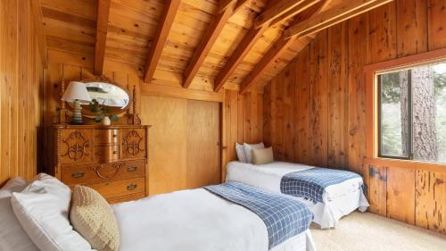 a bedroom with two beds in a wooden cabin at Sunnyside by AvantStay Charming Lake Tahoe Chalet on Tahoes West Shore in Tahoe City