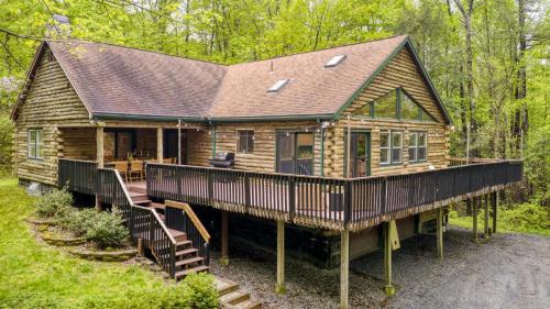a log cabin with a deck in the woods at Half Moon by AvantStay 4BR Cabin w Large Deck Yard w Patio Outdoor Dining in Great Barrington