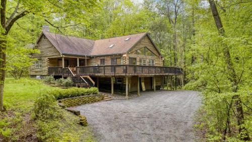 a large wooden house in the middle of a forest at Half Moon by AvantStay 4BR Cabin w Large Deck Yard w Patio Outdoor Dining in Great Barrington