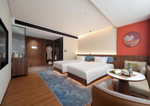 a hotel room with a bed and a table at Zhangjiajie Yujie Hotel in Zhangjiajie
